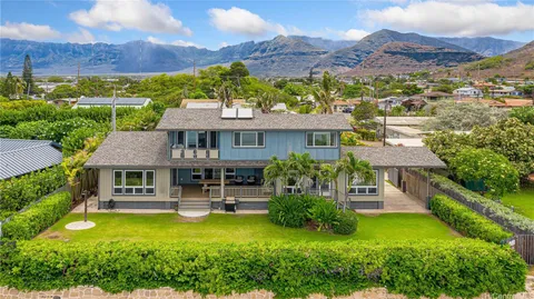 an aerial view of a house with swimming pool and a yard