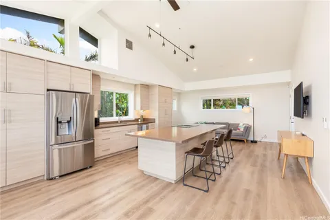 a kitchen with stainless steel appliances granite countertop a refrigerator a stove a sink dishwasher and a refrigerator with wooden floor