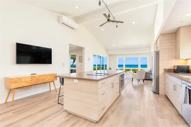 a large living room with stainless steel appliances kitchen island granite countertop furniture a flat screen tv and a faucet