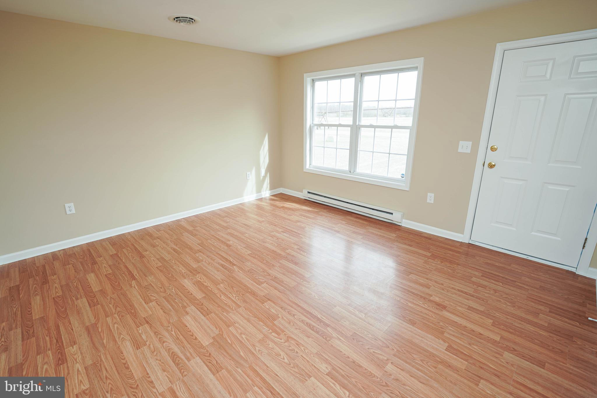 7526 Bethel Road Willards, MD 21874 - Photo 4 of 34 a view of an empty room with wooden floor and a window