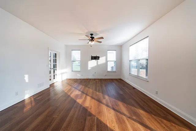wooden floor in an empty room with a window