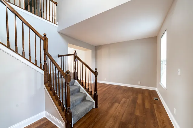 a view of a hallway with wooden floor and staircase