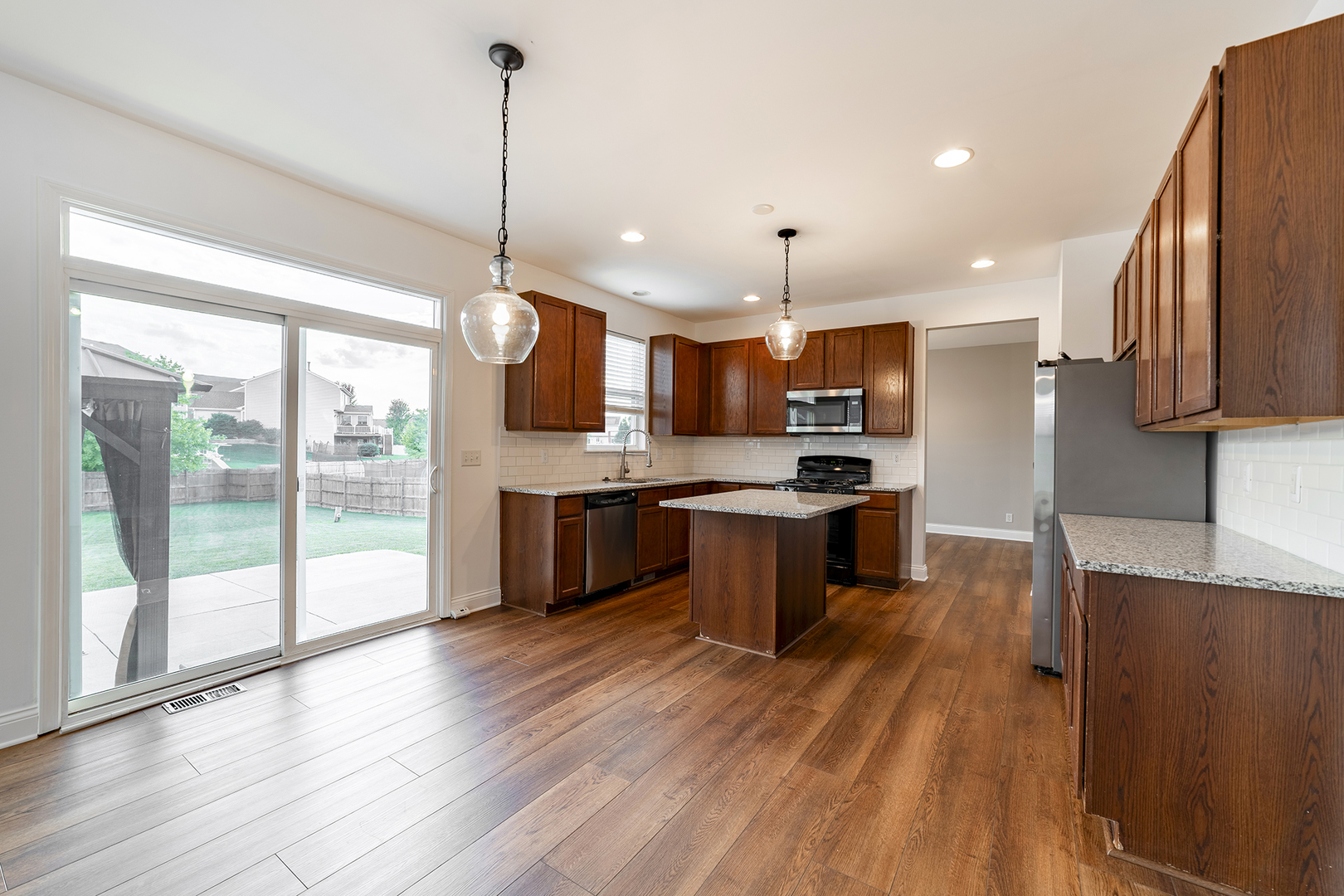 442 Windett Ridge Road Yorkville, IL 60560 - Photo 10 of 26 a kitchen with stainless steel appliances kitchen island granite countertop a stove a sink a refrigerator a center island with wooden floor and cabinets