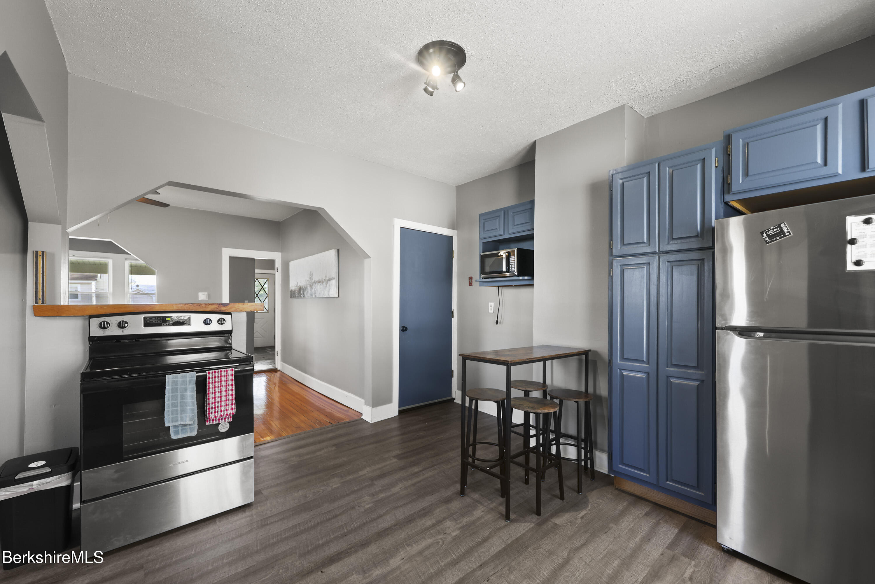 105-107 Onota Street Pittsfield, MA 01201 - Photo 14 of 46 a kitchen with stainless steel appliances granite countertop a refrigerator stove microwave and wooden floor