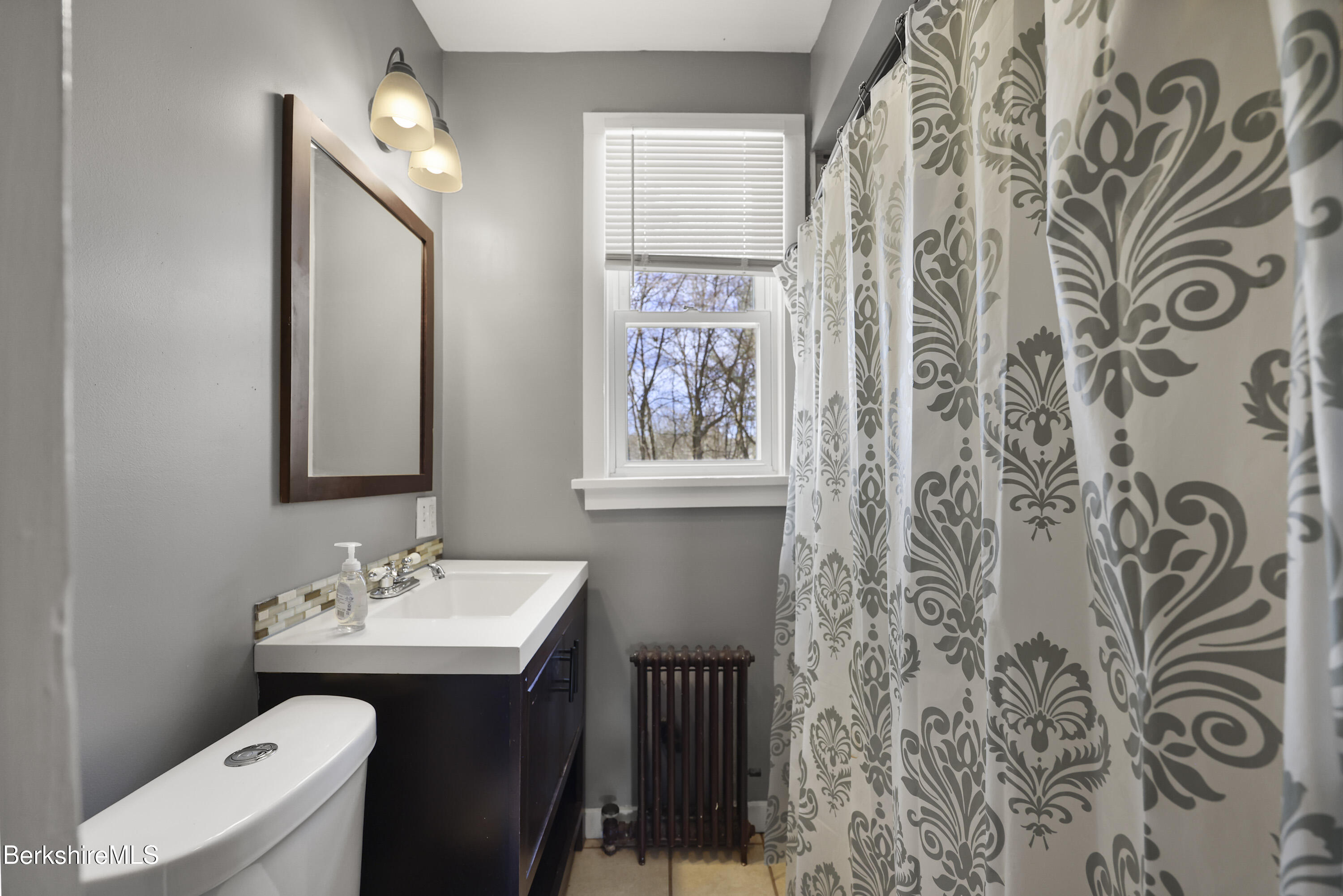105-107 Onota Street Pittsfield, MA 01201 - Photo 22 of 46 a bathroom with a sink and mirror with toilet