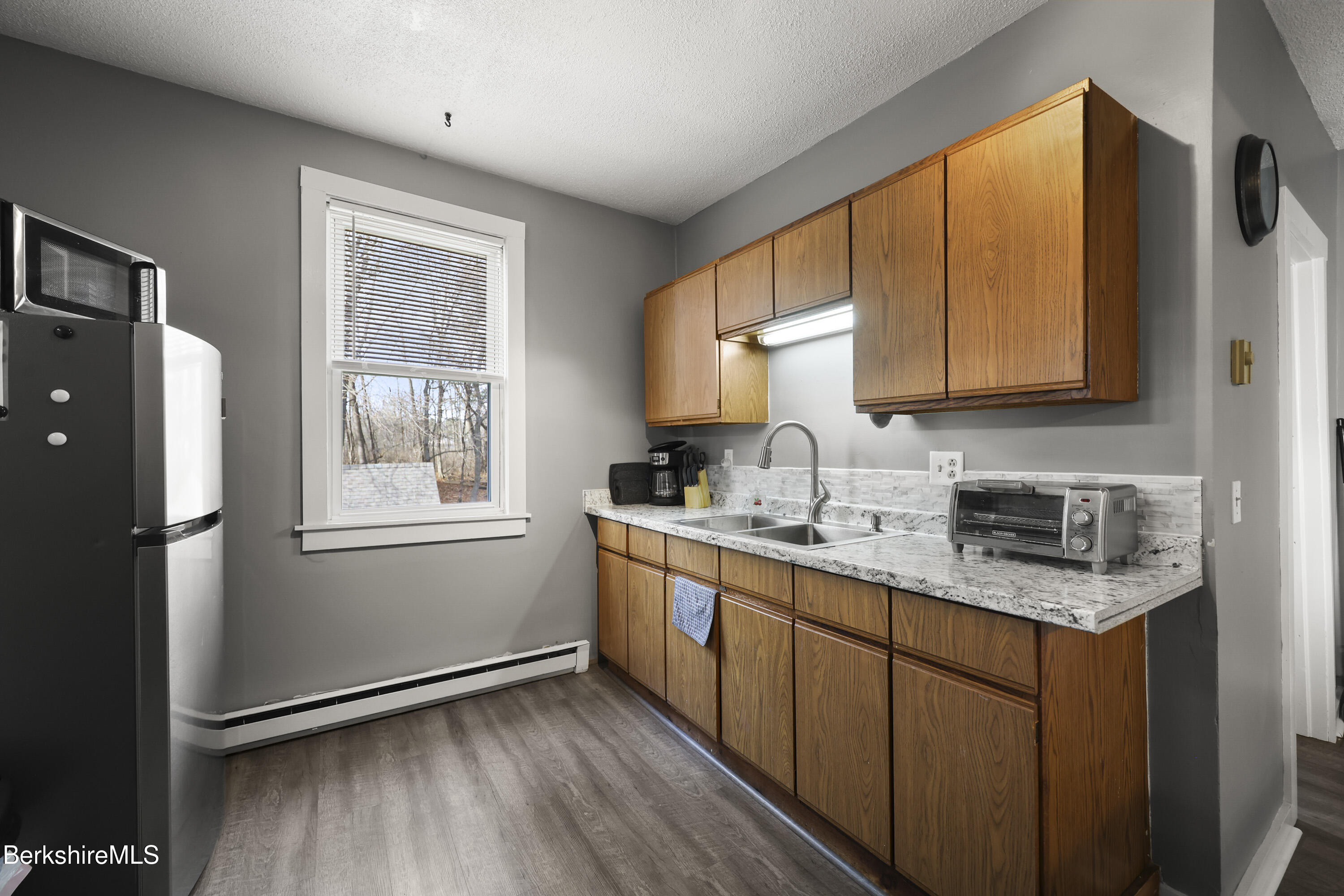 105-107 Onota Street Pittsfield, MA 01201 - Photo 32 of 46 a kitchen with stainless steel appliances granite countertop a sink cabinets and wooden floor