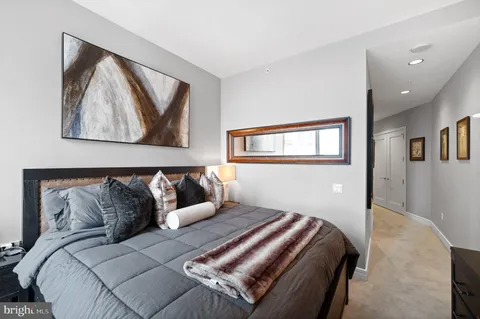 a bedroom with a bed and painting on the wall