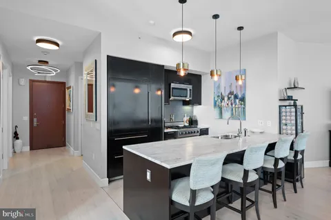 a kitchen with a refrigerator a sink and chairs