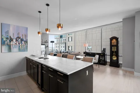 a kitchen with stainless steel appliances granite countertop a sink a counter space and living room view