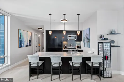 a kitchen with stainless steel appliances kitchen island granite countertop a dining table and chairs