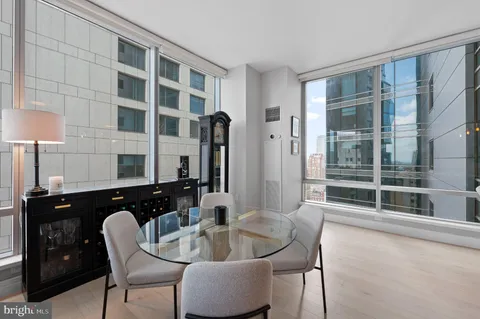 a dining room with furniture and a floor to ceiling window