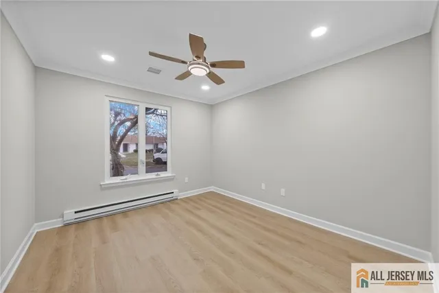 an empty room with windows and fan