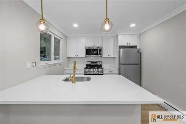 a kitchen with a refrigerator a stove top oven a sink and dishwasher with wooden floor