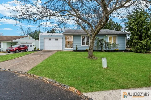 a front view of a house with a garden and trees