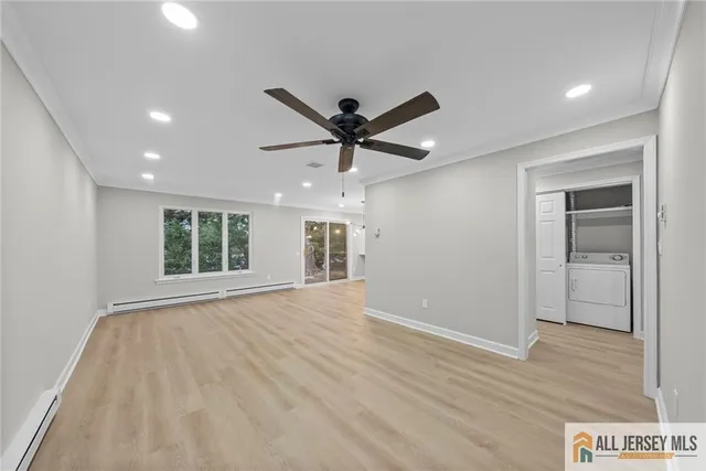 a view of empty room with wooden floor and ceiling fan