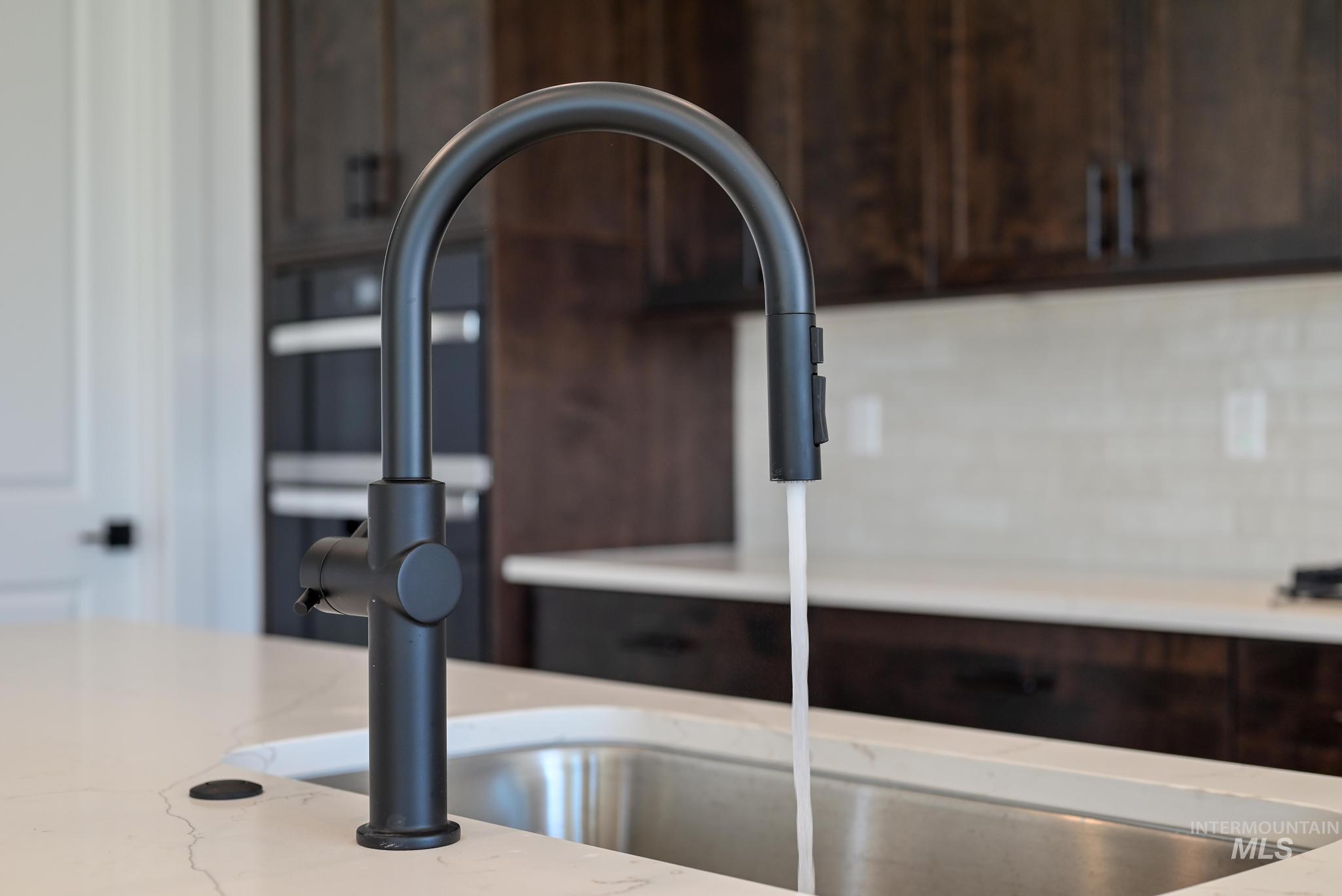 9085 West Patmore Court Star, ID 83669 - Photo 13 of 40 Kitchen view of dark brown cabinetry and light stone countertops