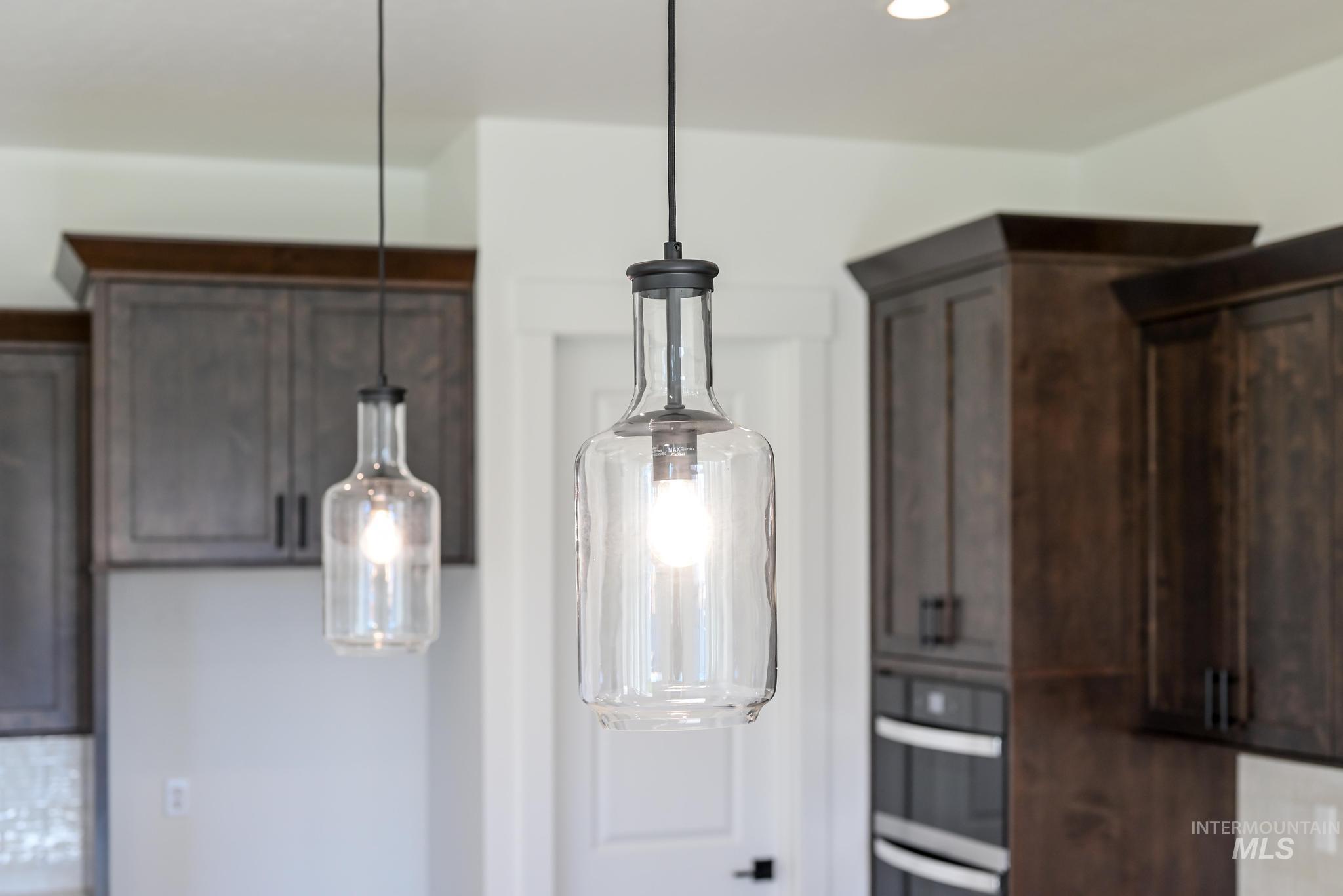 9085 West Patmore Court Star, ID 83669 - Photo 14 of 40 Kitchen view of decorative light fixtures, dark brown cabinetry, stainless steel double oven, and recessed lighting