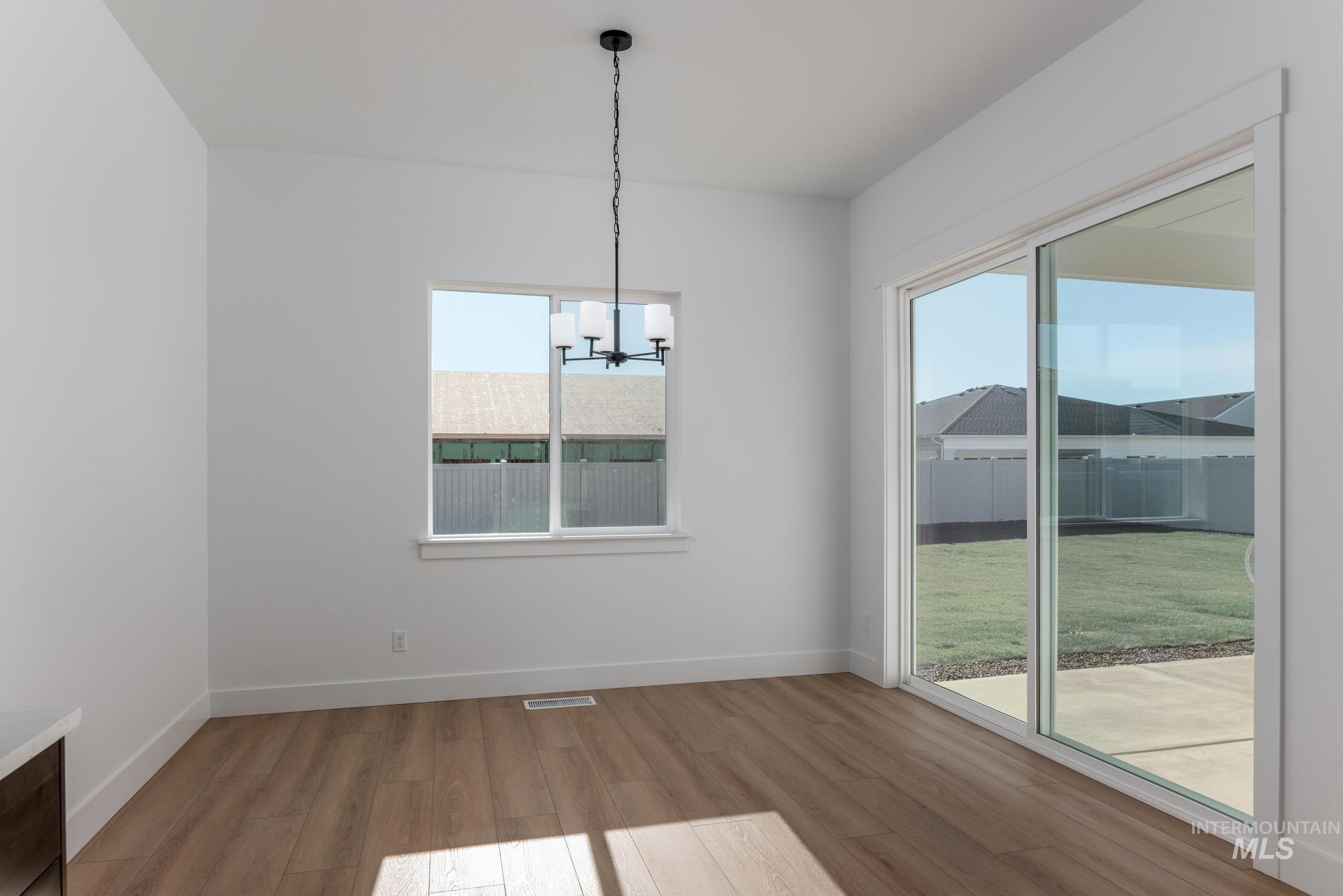 9085 West Patmore Court Star, ID 83669 - Photo 17 of 40 Unfurnished dining area featuring a chandelier and light wood-type flooring