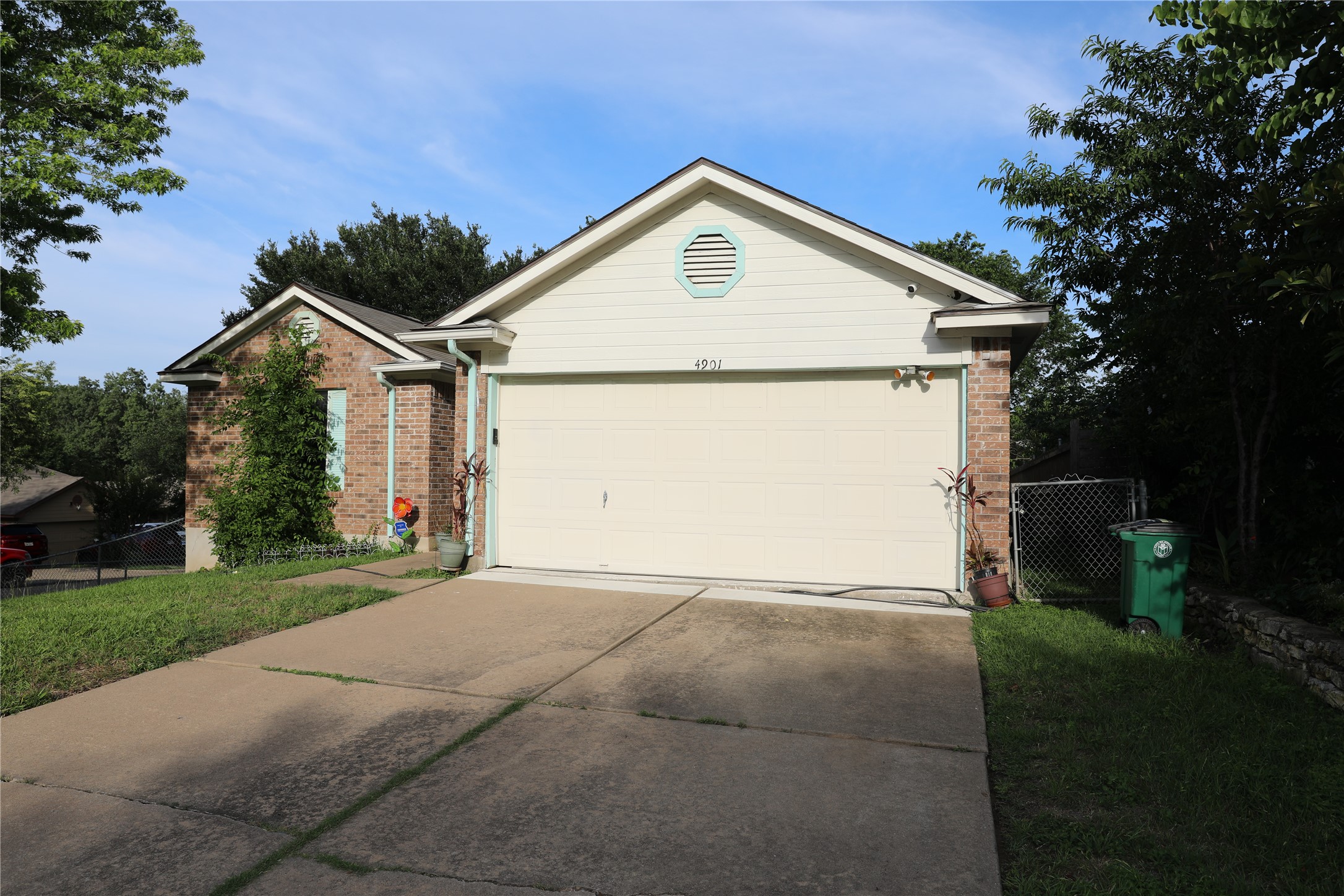 4901 Birch Creek Road Austin, TX 78744 - Photo 5 of 11 A classic brick and siding residence, featuring an integrated garage and concrete driveway.
