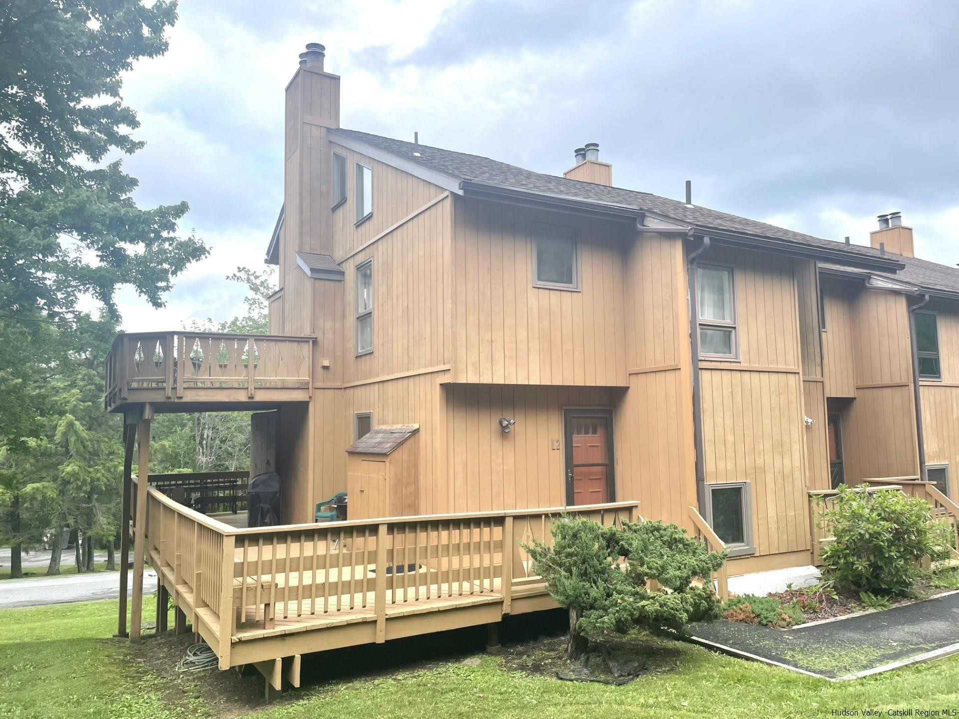 a view of a white house with a small yard and wooden fence