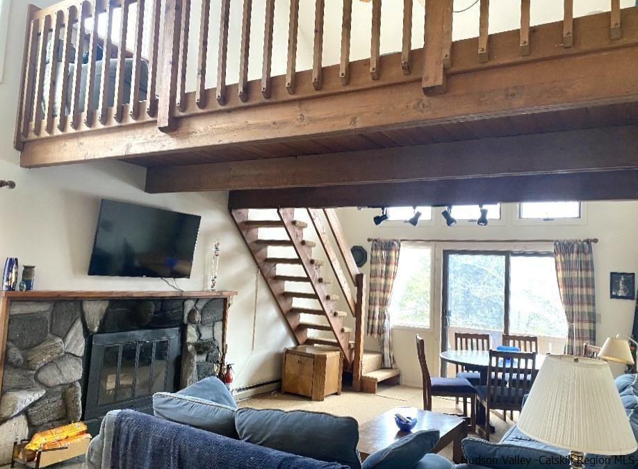 72 Hunter Ridge, Unit L1 Hunter, NY 12442 - Photo 12 of 23 a living room with furniture a flat screen tv and a large window