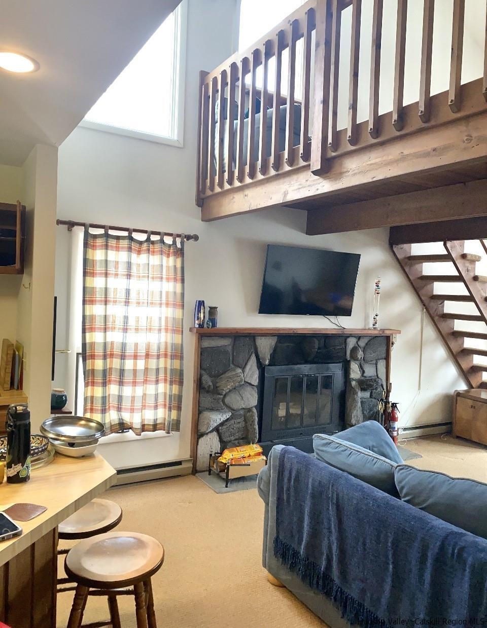 72 Hunter Ridge, Unit L1 Hunter, NY 12442 - Photo 8 of 23 a living room with furniture a fireplace and a large window