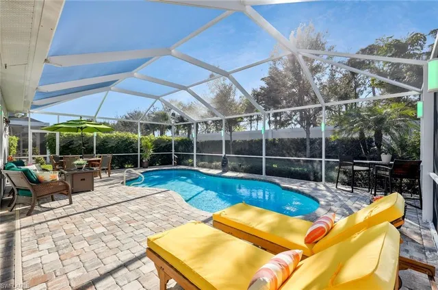 a view of a backyard with swimming pool and sitting area