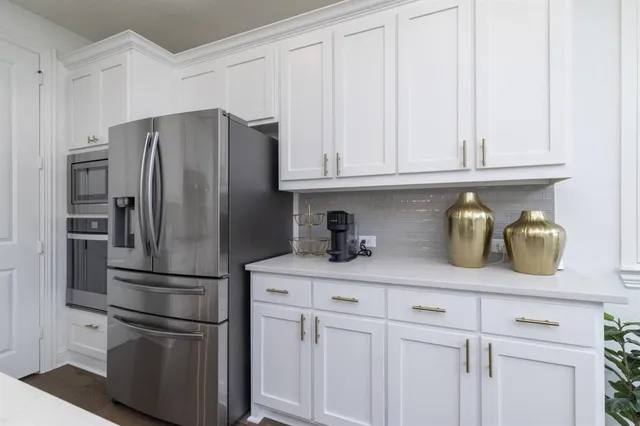 a kitchen with refrigerator and cabinets