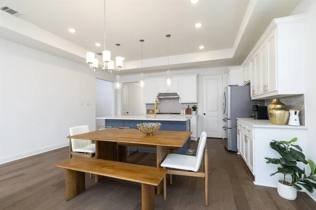 a room with stainless steel appliances kitchen island granite countertop furniture and a wooden floor