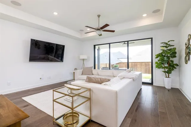 a living room with furniture a flat screen tv and a large window
