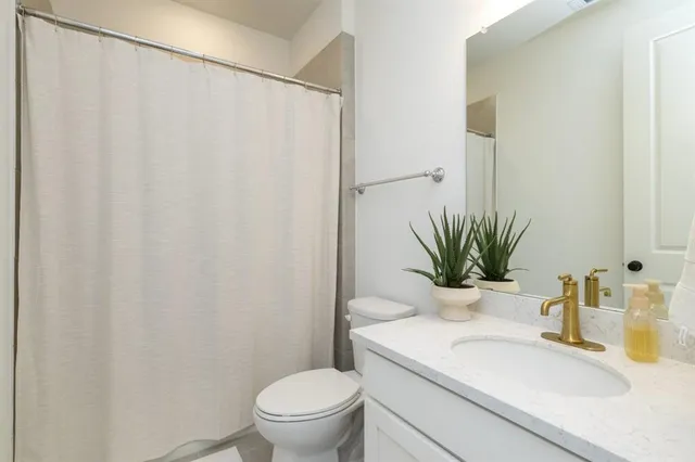 a bathroom with a sink a toilet and a mirror