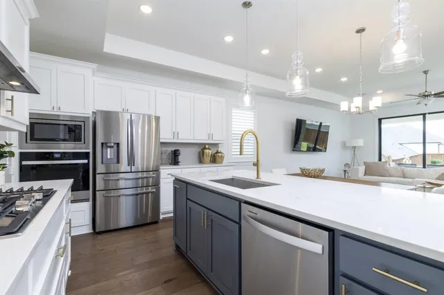 a kitchen with a sink stainless steel appliances and white cabinets