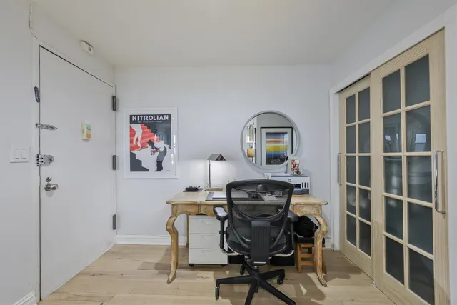 a view of a workspace with furniture and a window