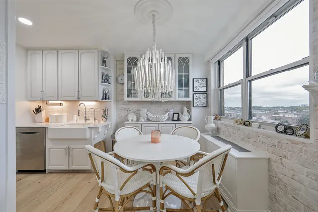 a dining room with furniture a chandelier and wooden floor