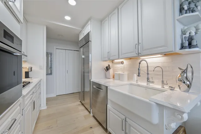 a kitchen with stainless steel appliances granite countertop a sink stove and refrigerator