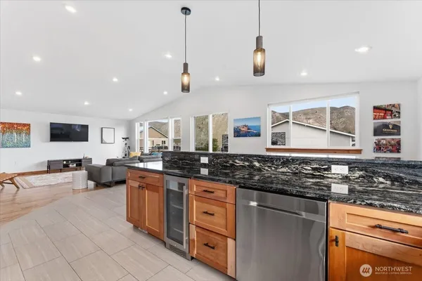 a kitchen with stainless steel appliances granite countertop a stove a sink and a refrigerator