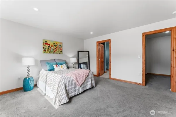 a bedroom with bed and a large mirror
