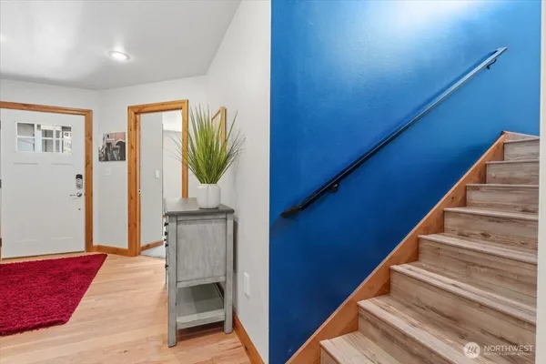a view of a hallway with wooden floor and staircase