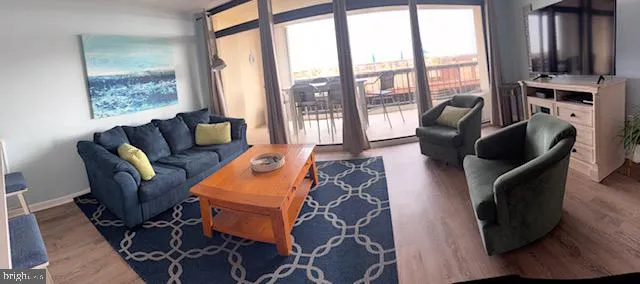 a living room with furniture a flat screen tv and a floor to ceiling window