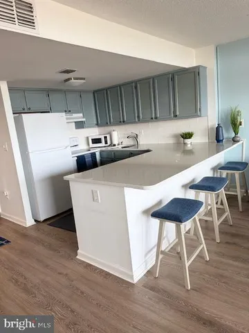 a kitchen with stainless steel appliances a dining table chairs and wooden floor