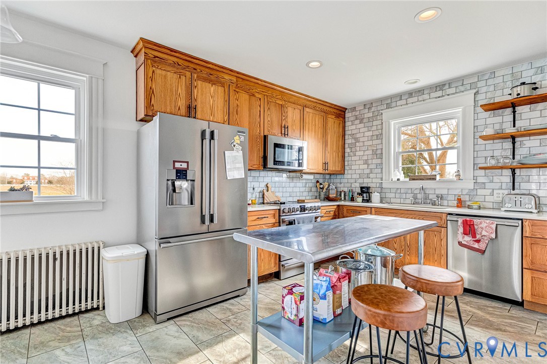 2172 Piping Tree Ferry Road Mechanicsville, VA 23111 - Photo 17 of 50 a kitchen with stainless steel appliances granite countertop a refrigerator a sink a stove a dining table and chairs