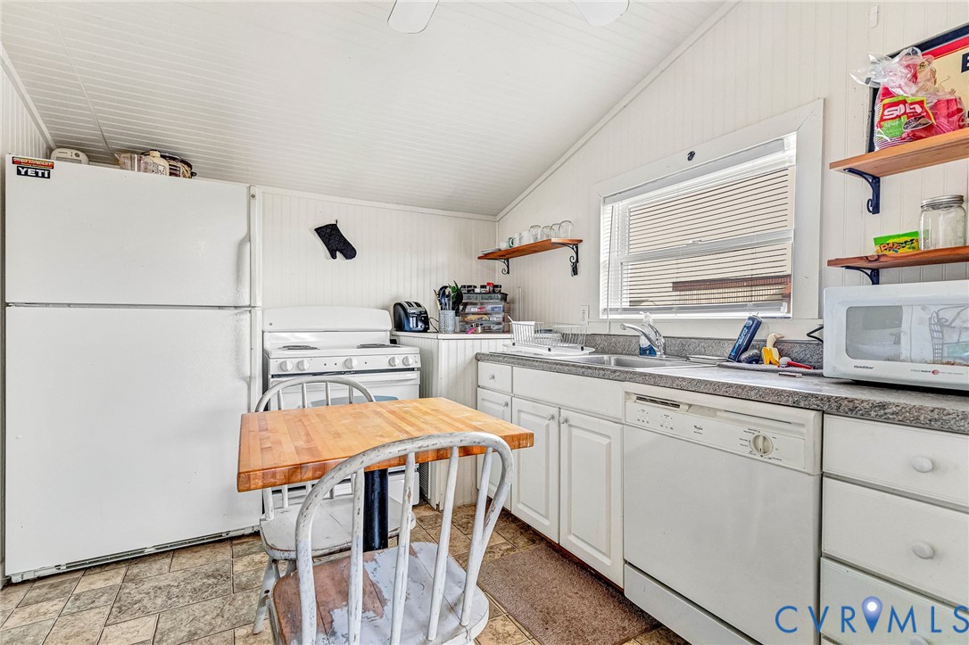 2172 Piping Tree Ferry Road Mechanicsville, VA 23111 - Photo 32 of 50 a kitchen with stainless steel appliances a white table chairs and a refrigerator