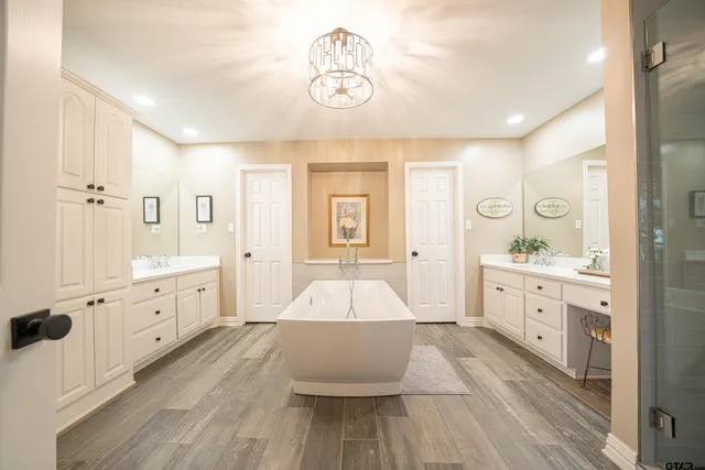 a spacious bathroom with a double vanity sink a mirror and a bathtub