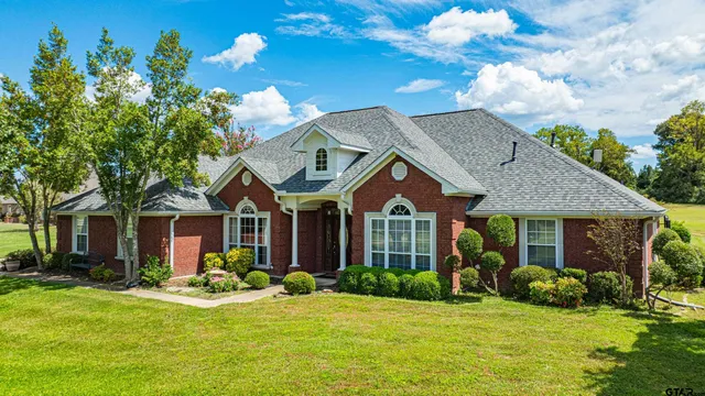 a front view of a house with a garden and plants