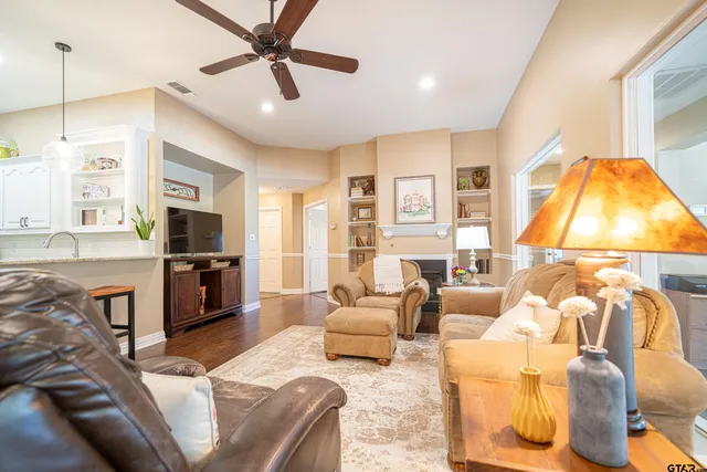 a living room with furniture a flat screen tv and kitchen view