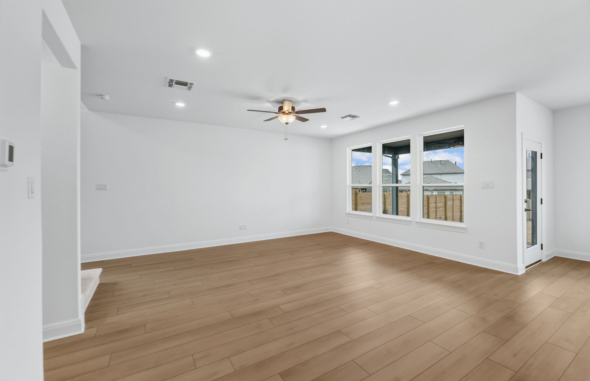 421 Foresail Road Leander, TX 78641 - Photo 5 of 28 a view of an empty room with wooden floor and a ceiling fan