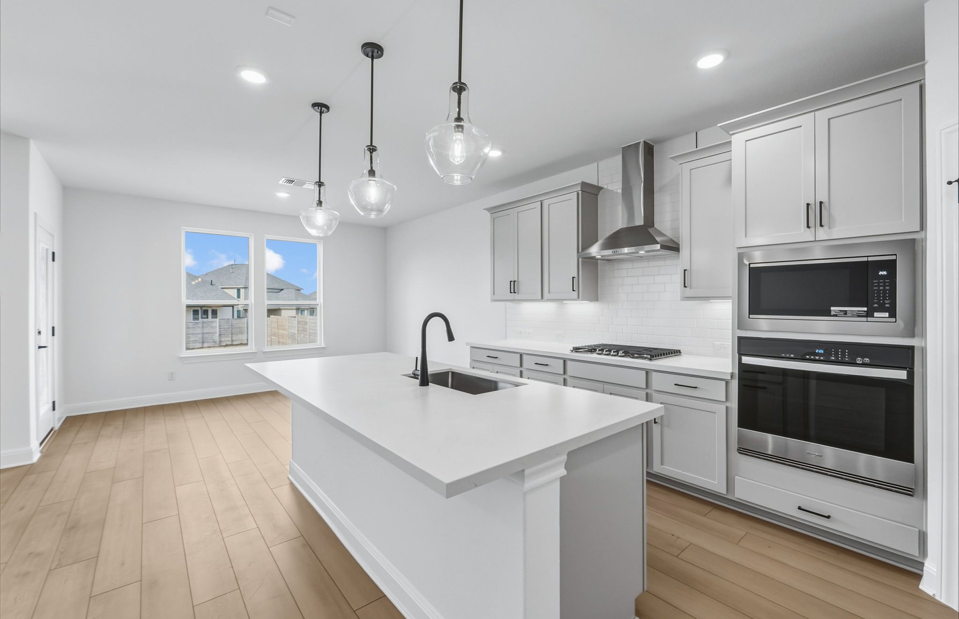 421 Foresail Road Leander, TX 78641 - Photo 8 of 28 a kitchen with stainless steel appliances granite countertop a sink a stove a refrigerator and a oven with wooden floor