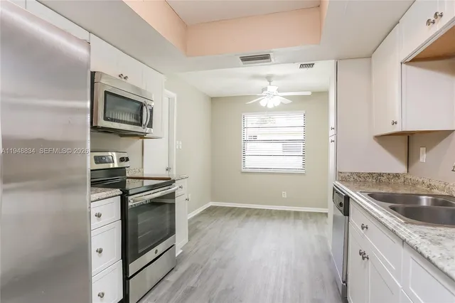 a kitchen with granite countertop a sink and steel appliances