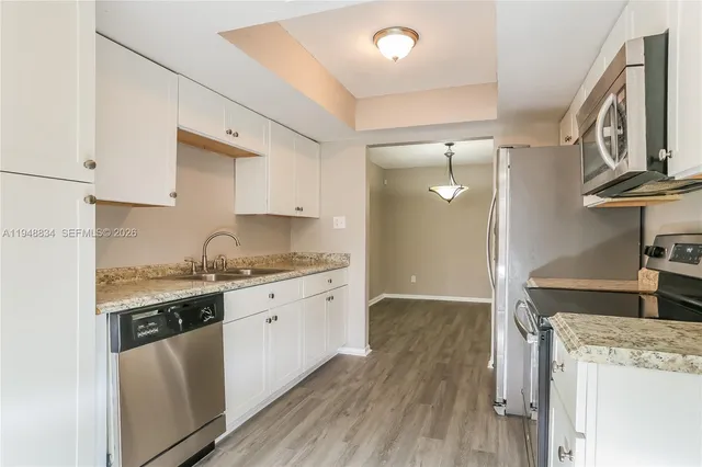 a kitchen with granite countertop a stove and a sink