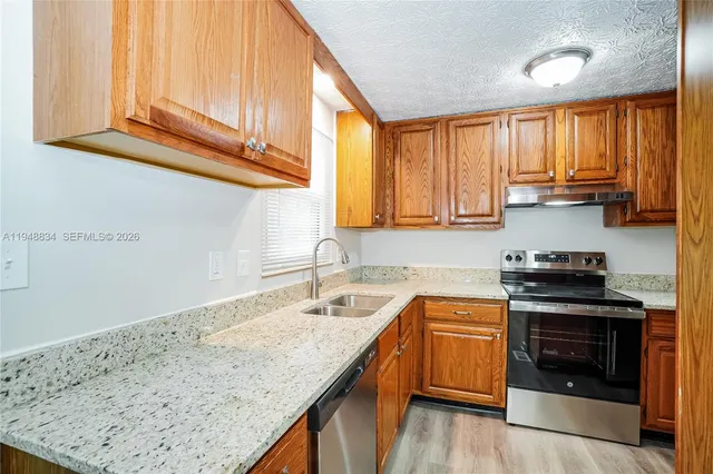 a kitchen with a sink stove top oven and cabinets